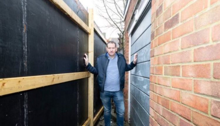 房主在建造者举起篱笆后愤怒地阻挡了他的车库门