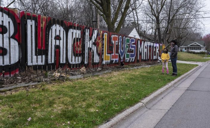 GuillermoMaldonadoPérez与他的女儿卢尔德，7，围栏，在西圣保罗，明尼苏达州的“黑色生命数”壁画于2021年4月10日。（Joshua Rashaad McFadden /纽约时报）